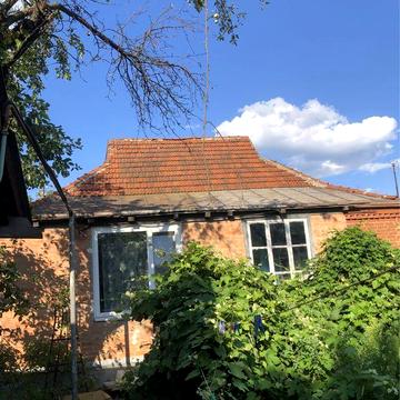 Окремий цегляний будинок біля річки.