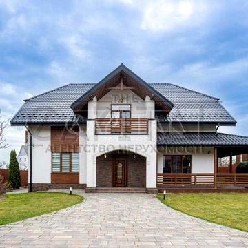Пропонується стильний дизайнерський будинок площею 205 м² у селі Хотов — лише 7 хвилин до Києва. Локація поєднує тишу заміського життя